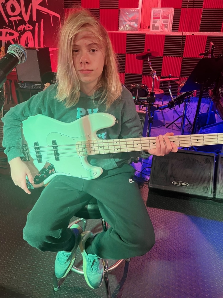 Student holding a bass for his first lesson