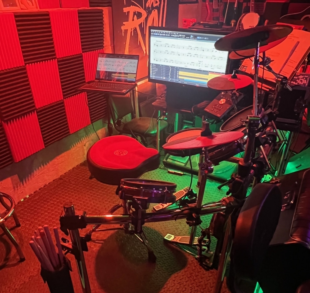 Drums and monitors along with laptop on drum riser
